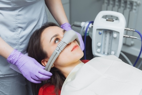 dentist puts inhalation sedative mask on his patient. Sedation dentistry