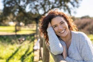 Happy,Woman,Smiling,At,Camera,In,A,Field